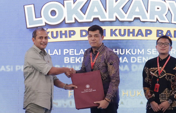 Kakanwil Kemenkum Riau Rudy Hendra Pakpahan (tengah) menerima penghargaan terbaik satu post test lokakarya KUHP dan KUHAP baru di UGM dari Wamenkum RI Edwar OS Hiariej, Kamis (12/2/2026).