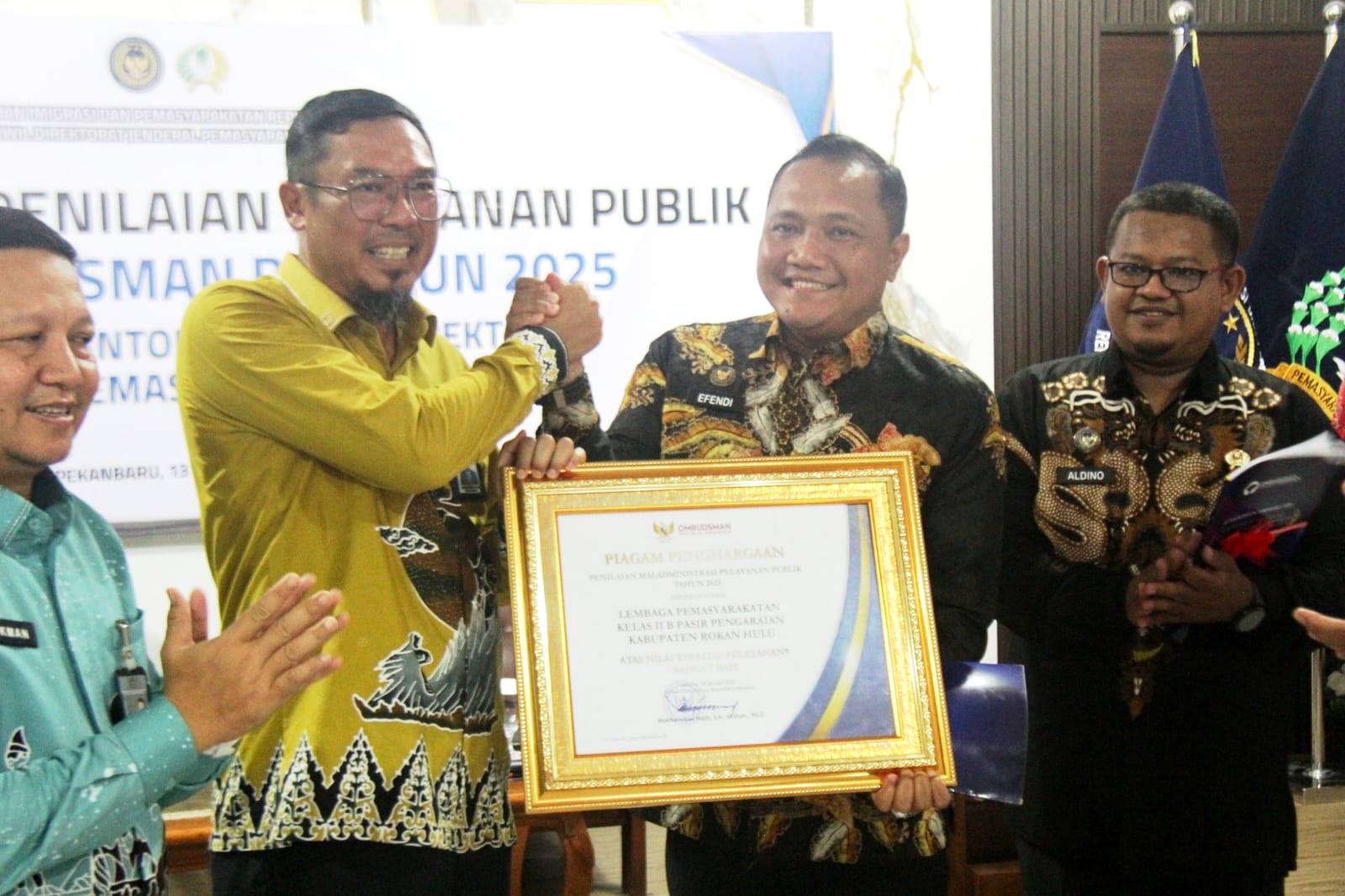 Kalapas Kelas IIB Pasirpengaraian Efendi Parlindungan Purba menerima piagam penghargaan dari Kepala Ombudsman RI Perwakilan Riau Bambang Pratama di Kanwil Ditjenpas Riau di Pekanbaru.Jumat (13/2/2026)