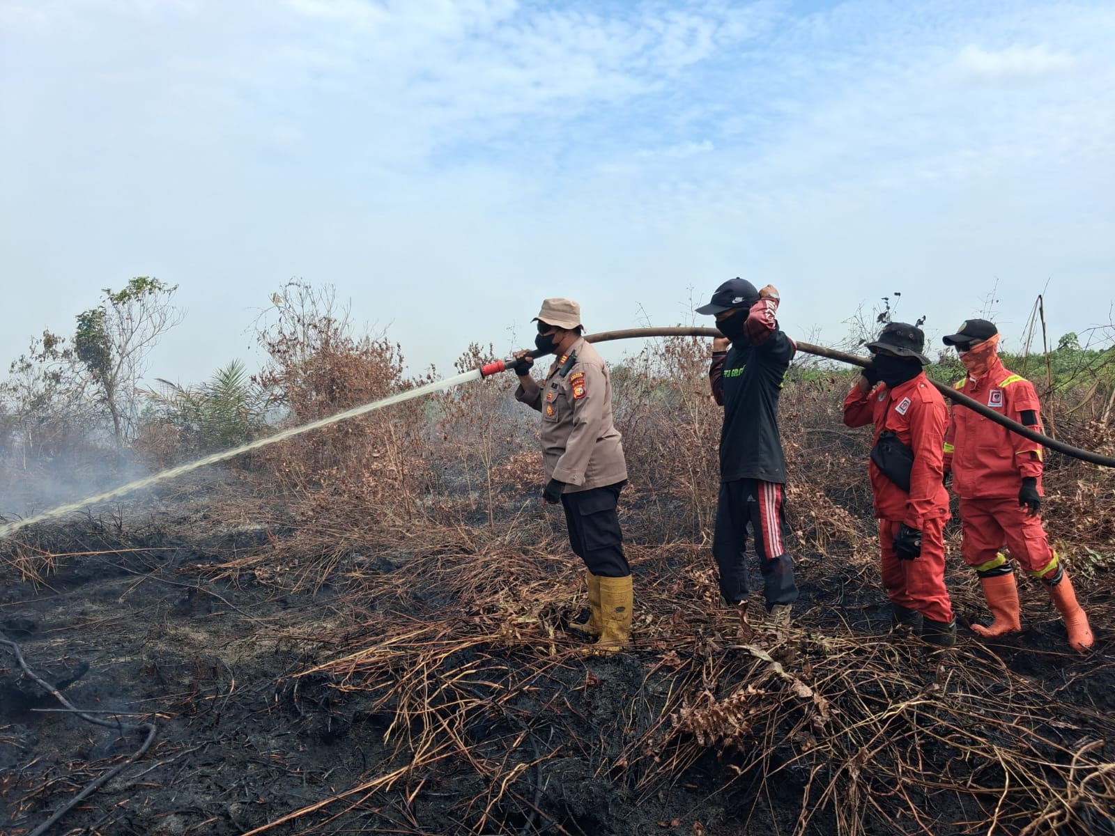 Kapolsek Rupat AKP Faisal bersama tim gabungan saat berjibaku memadamkan dan mendinginkan api di Desa Sukarjo Mesim, Kecamatan Rupat, Bengkalis, Sabtu (14/2/2026).