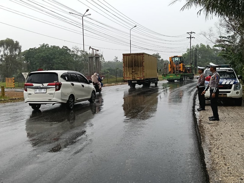 Petugas Satlantas Polres Bengkalis mengatur lalu lintas di lokasi tumpahan CPO di Jalan Lintas Duri-Pekanbaru, Ahad (15/2/2026) siang.