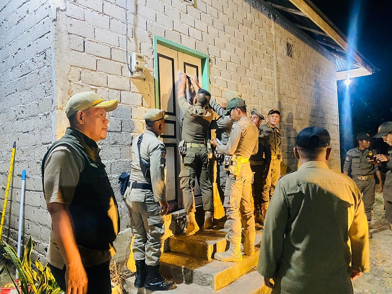 Personel Satpol PP-PKP memasang SE Bupati Kuansing tetang aturan selama bulan Ramadhan di cafe remang-remang di Kecamatan Kuantan Tengah, Sabtu (14/2/2026) malam.