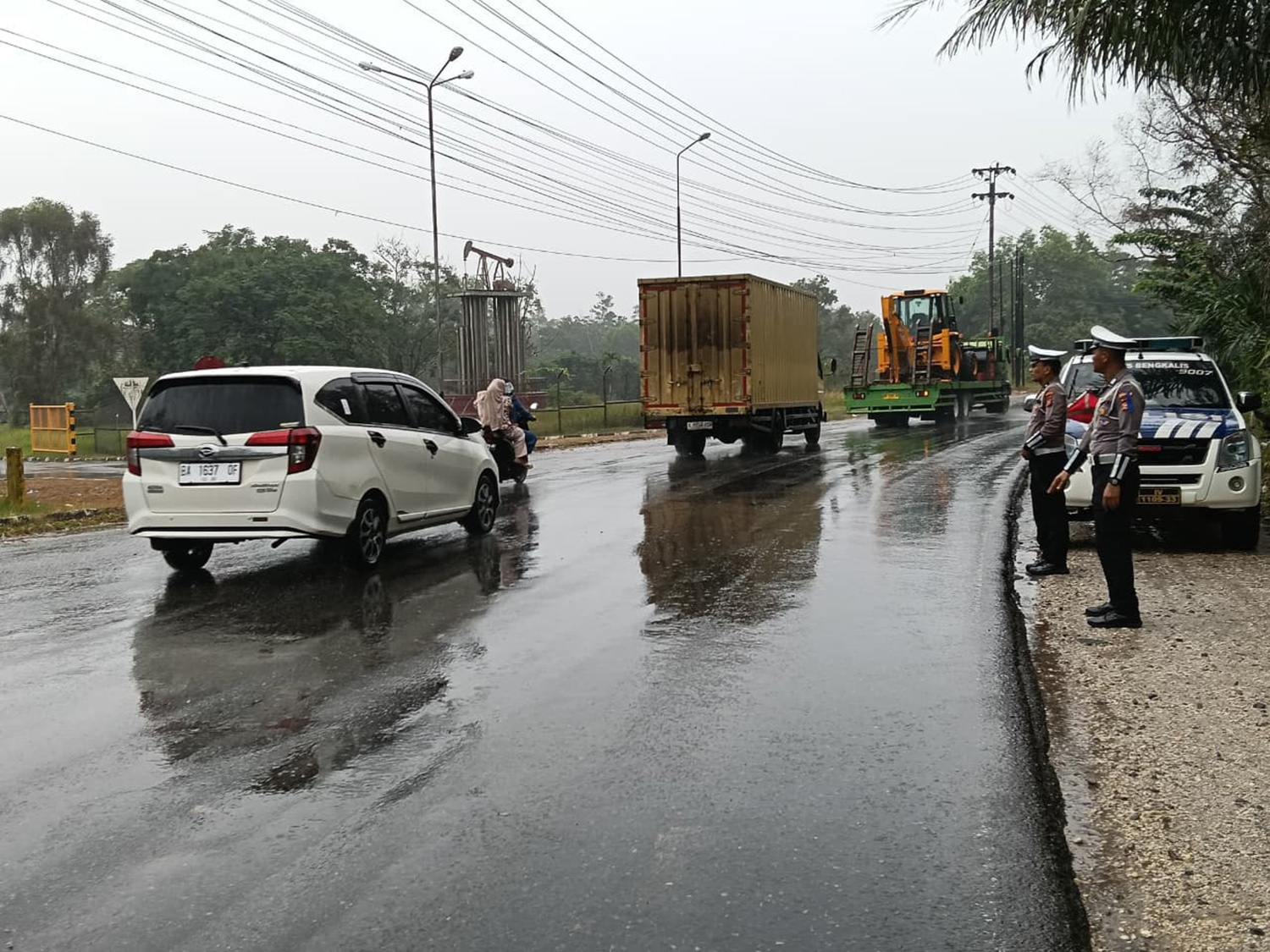 Petugas Satlantas Polres Bengkalis mengatur lalu lintas di lokasi tumpahan CPO di Jalan Lintas Duri-Pekanbaru, Ahad (15/2/2026) siang.