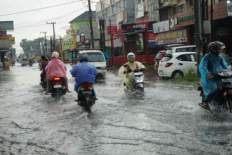 Pengendara melintas di Jalan Delima yang tergenang air, Senin (16/2/2026).