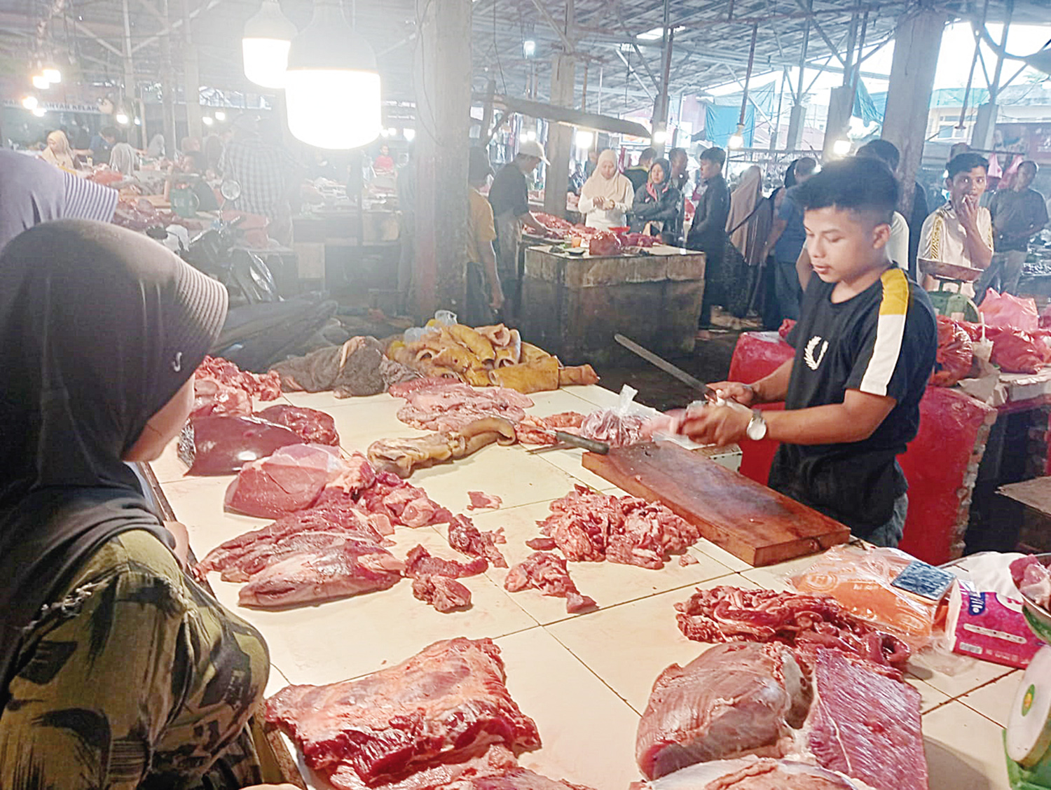 Pedagang melayani pembeli yang berbelanja daging sapi di Pasar Dupa Pekanbaru, Ahad (15/2/2026). Harga daging sapi di pasar ini dijual Rp140 ribu per kilogram.