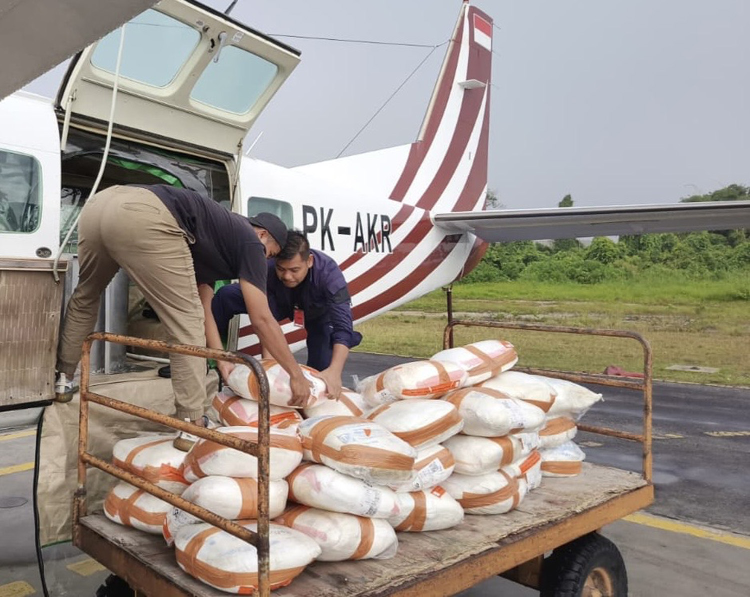 Personel tim Operasi Modifikasi Cuaca memasukkan NaCl ke dalam Pesawat Cessna Grand Caravan 208B Reg PK-AKR persiapan menuju Bengkalis dan Siak, Selasa (17/2/2026).