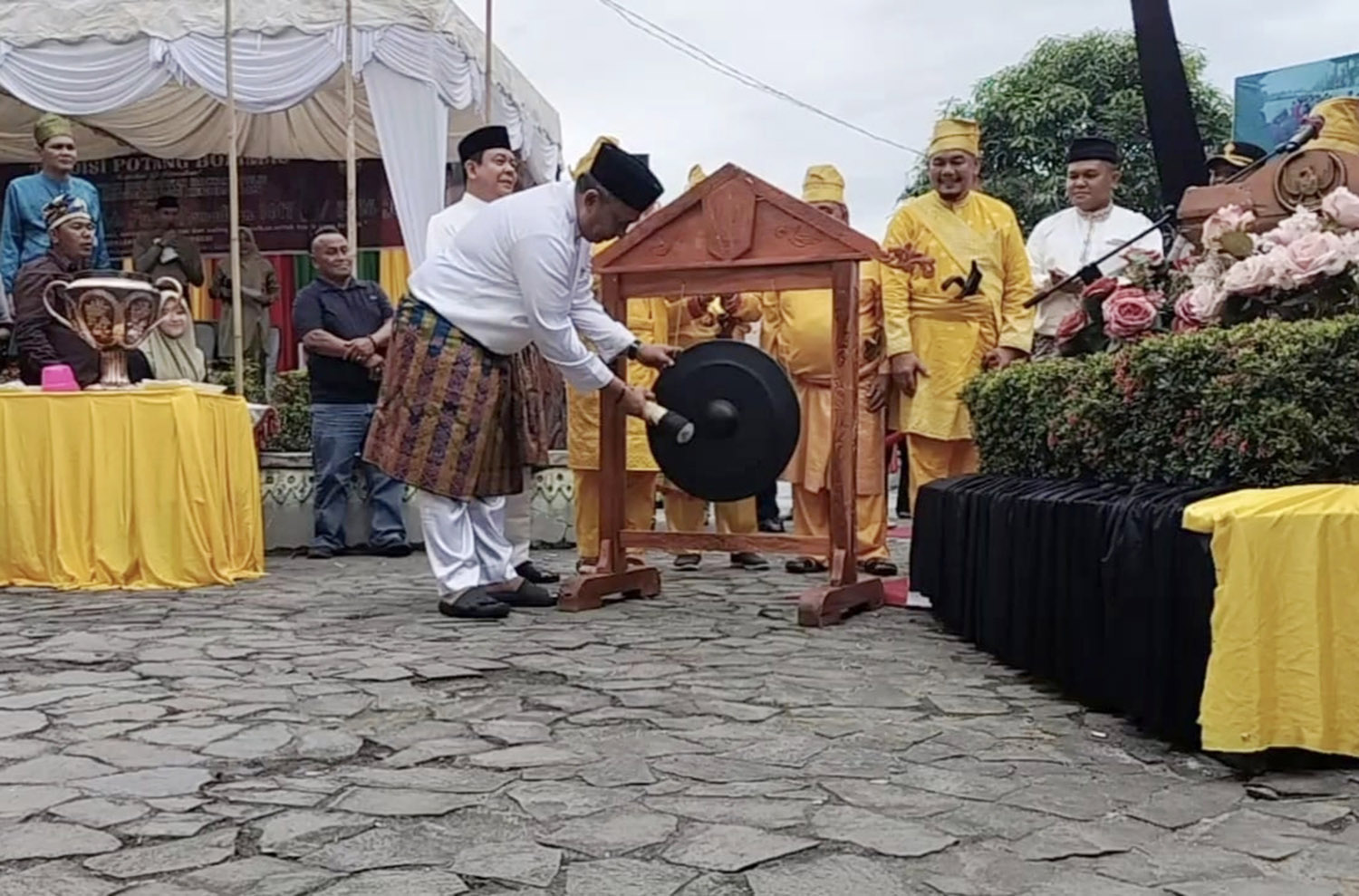Bupati Rohul Anton ST MM memukul gong tanda dibukanya prosesi tradisi potang bolimau tingkat kabupaten yang dipusatkan di Waterfront City Pujasera Pasirpengaraian, Selasa (17/2/2026).