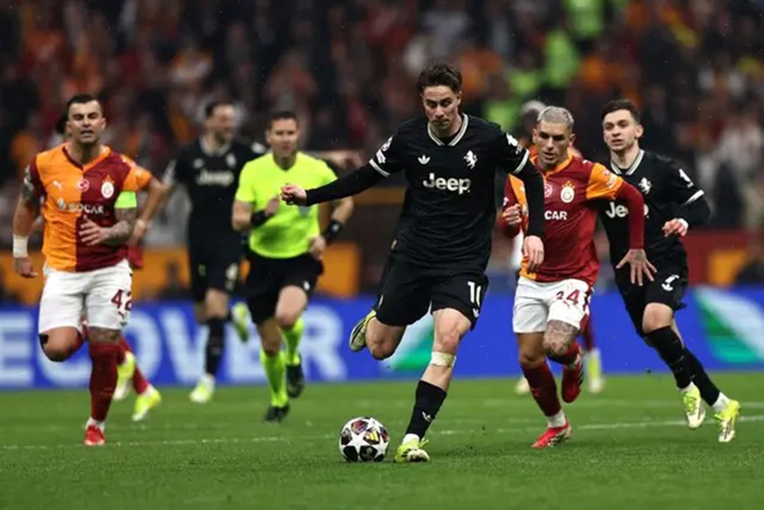 Penyerang Juventus, Kenan Yildiz, menggiring bola dengan kawalan pemain Galatasaray dalam leg pertama babak gugur Liga Champions UEFA 2025/26 di Ali Sami Yen Spor Kompleksi, Istambul, Turki, Rabu (18/