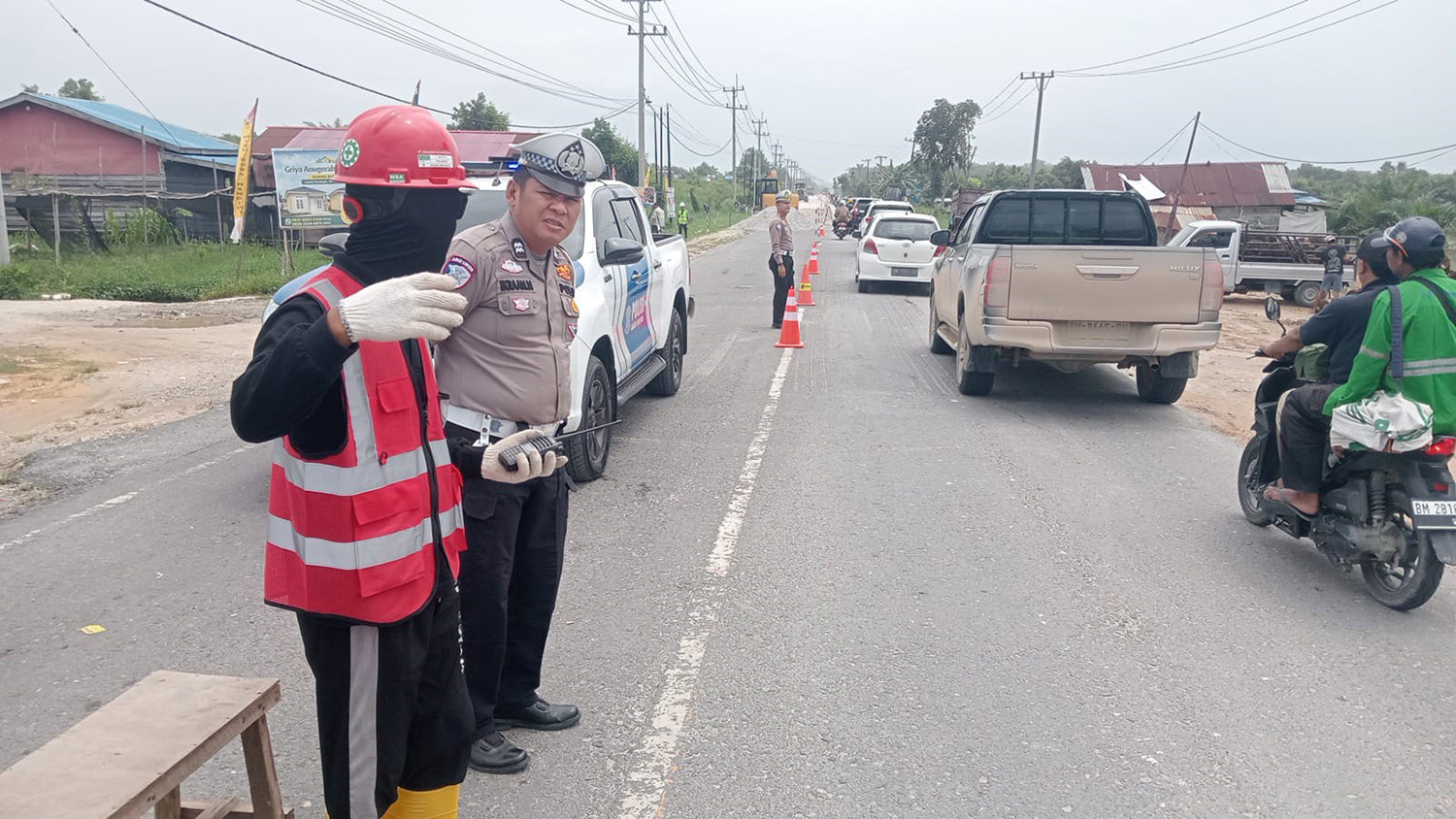 Personel Satlantas Polres Pelalawan melakukan pengaturan lalu lintas saat penerapan sistem buka tutup di Jalan Lintas Timur Km 75 Pangkalankerinci, Pelalawan, Kamis (19/2/2026).
