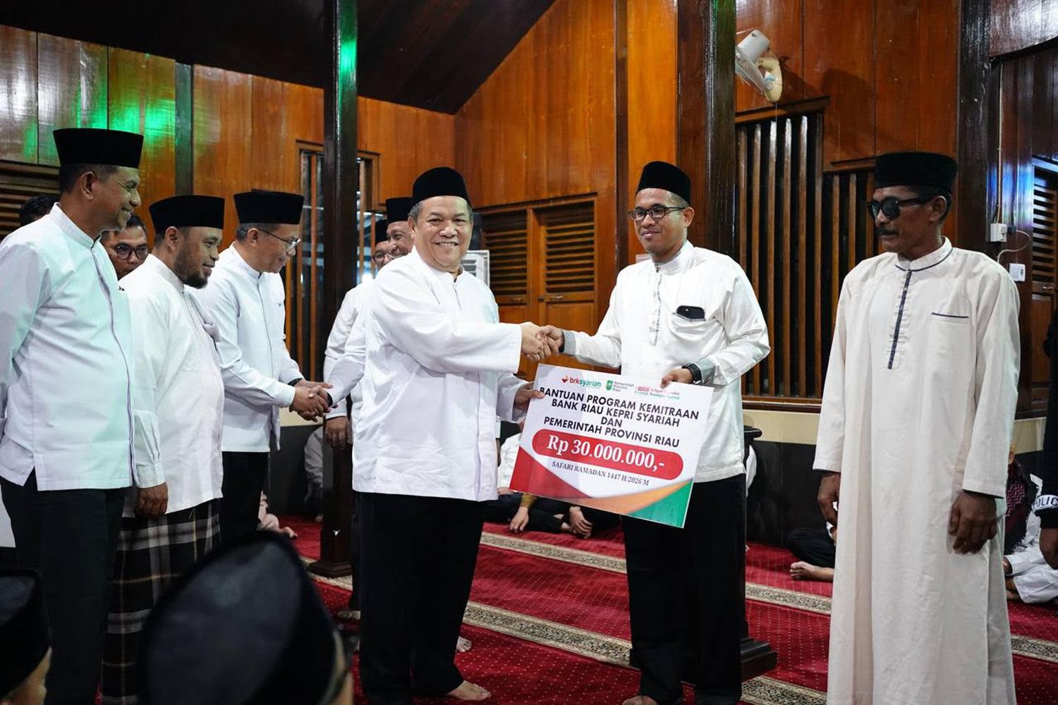 Pelaksana tugas Gubernur Riau SF Hariyanto menyerahkan bantuan kepada pengurus masjid saat Safari Ramadan di Masjid Raya Darussalam, Kelurahan Kotalama, Kecamatan Kunto Darussalam, Kabupaten Rohul
