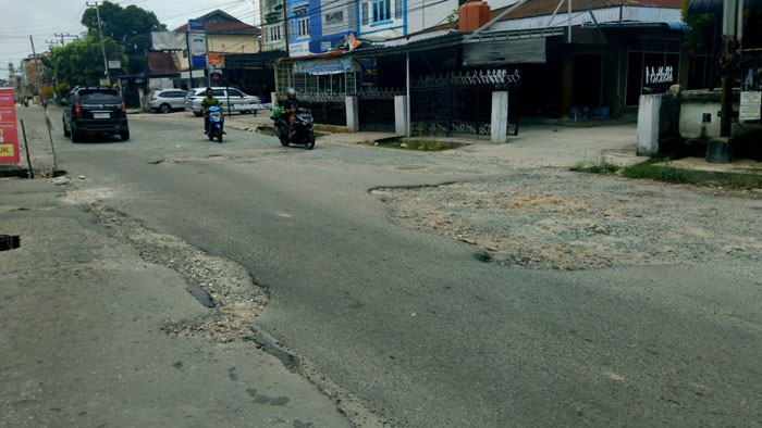 Ruas Jalan Cempaka rusak bertahun-tahun, badan aspal mengelupas dan berlubang.