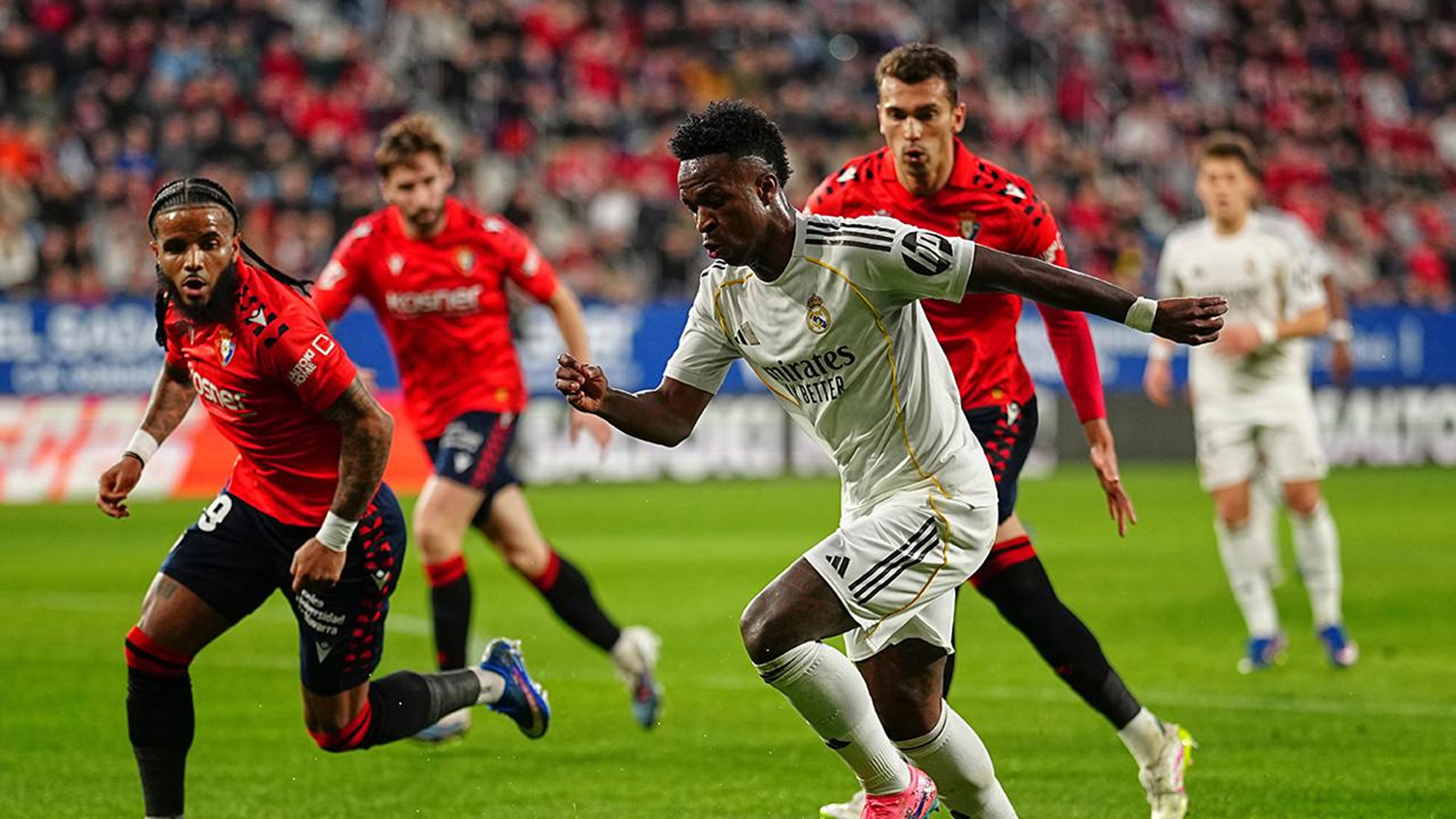 Penyerang Real Madrid, Vinicius Junior dikawal bek Osasuna Valentin Rosier dalam laga Liga Spanyol di Estadio El Sadar, Ahad (22/2/2026). 