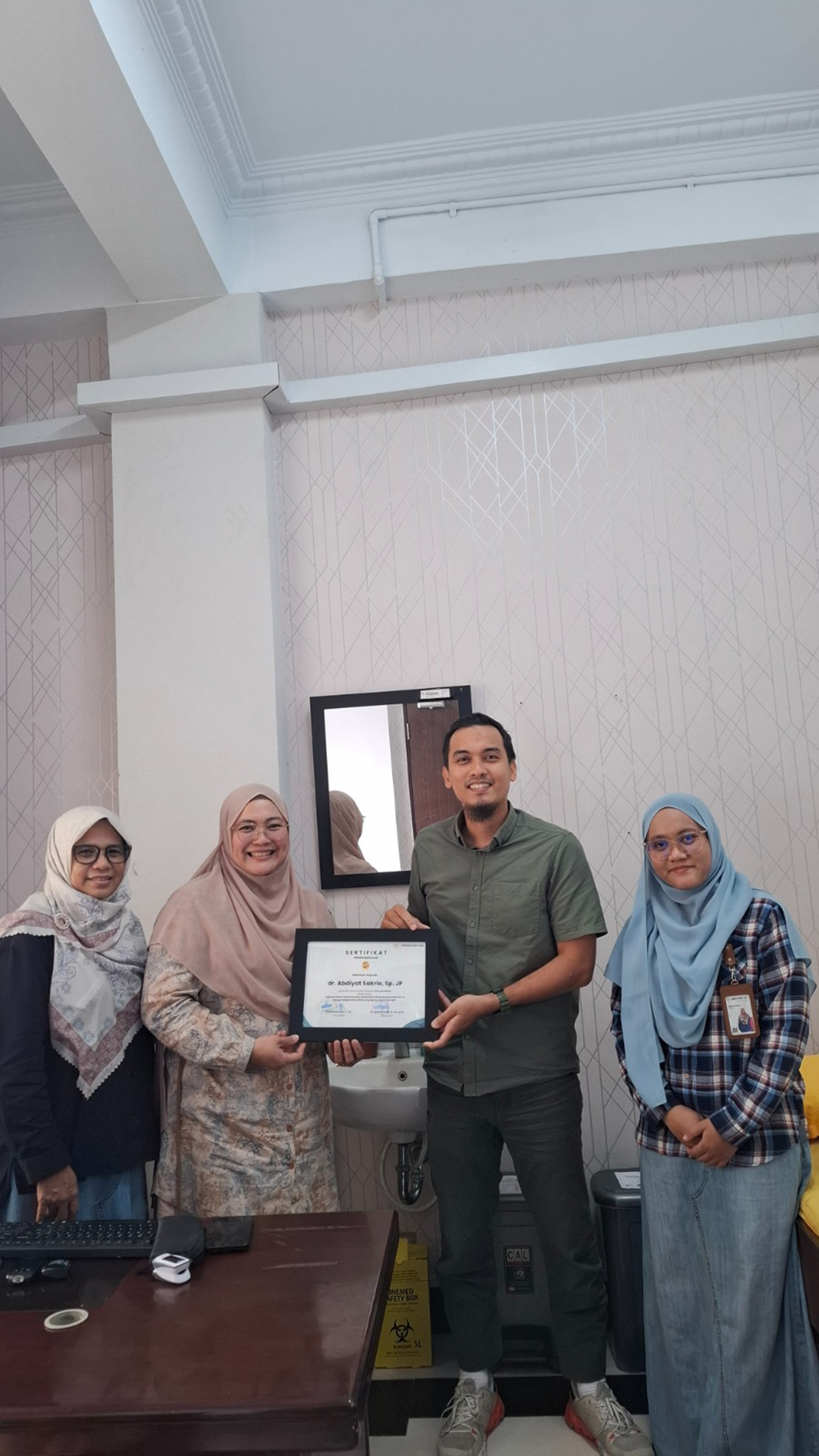 Ketua Tim peneliti dari Po&shy;liteknik Caltex Riau (PCR) Putri Madona SST MT menyerahkan ser&shy;tifikat kepada dokter spesialis jantung RS Syafira, dr Abdiyat Syakrie Sp JP usai FGD di RS Syafira, baru-baru