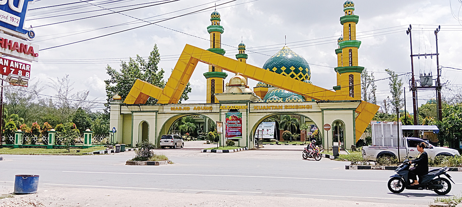 Warga melintas di gerbang masuk Masjid Agung Ar Raudhah Kabupaten Kuantan Singingi di Jalan Proklamasi Nomor 1, Kelurahan Sungai Jering, Kecamatan Kuantan Tengah, Senin (23/2/2026).