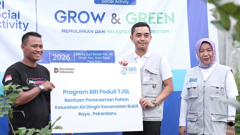 Regional CEO BRI Pekanbaru, Dian Kesuma Wardhana (tengah) menyerahkan bantuan penanaman pohon di Kelurahan Air Dingin, Kecamatan Bukit Raya, Pekanbaru, Jumat (21/2/2026).