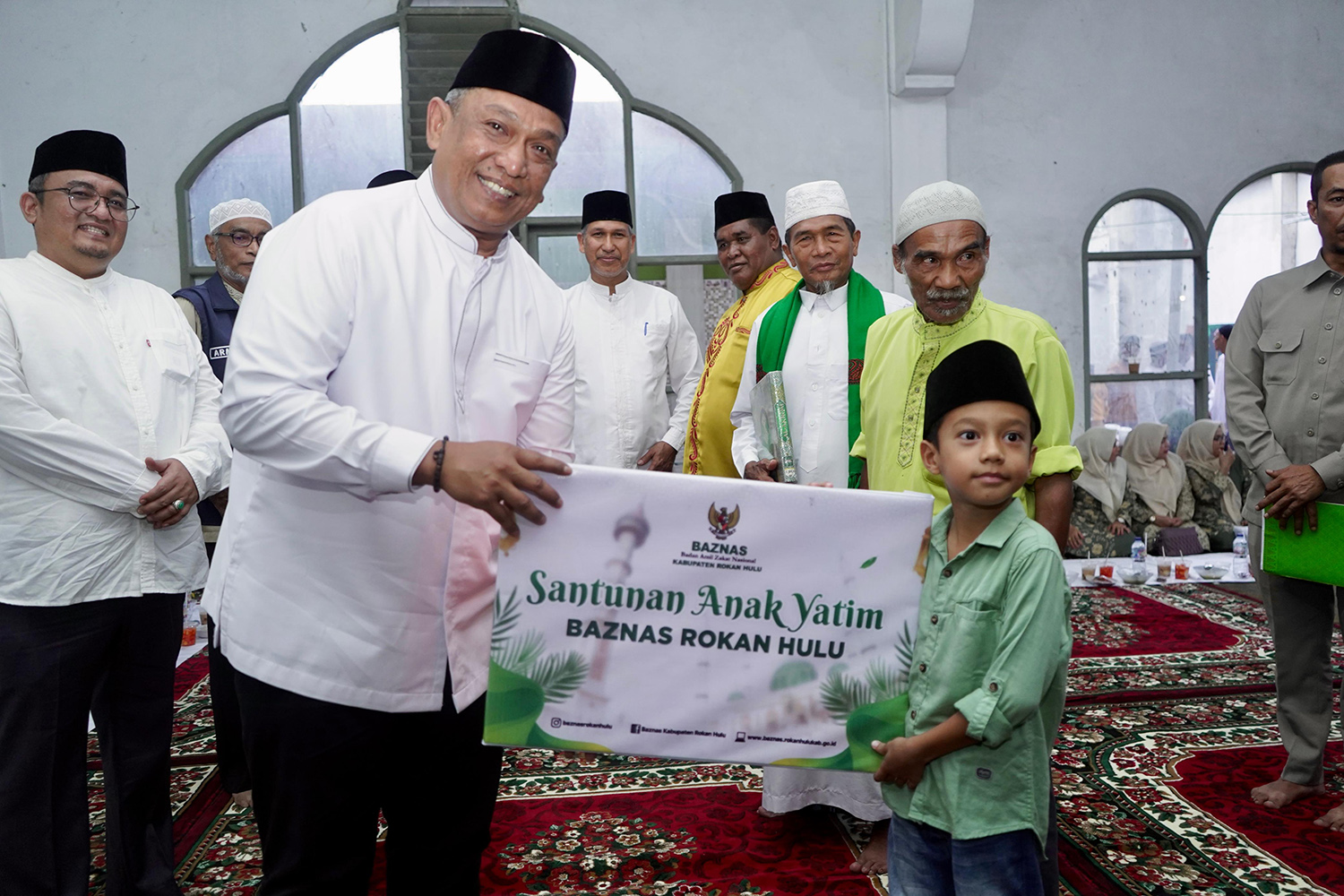 Bupati Rohul Anton menyerahkan santunan anak yatim dari bantuan Baznas Rohul dalam kunjungan Safari Ramadan perdana di Masjid Jami&rsquo;atul Mukarromah Desa Suka Maju, Kecamatan Rambah, Senin (23/2/2026).