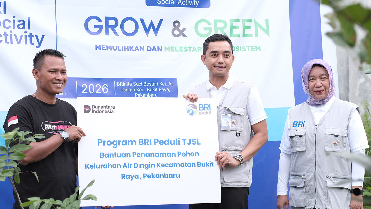 Regional CEO BRI Pekanbaru, Dian Kesuma Wardhana (tengah) menyerahkan bantuan penanaman pohon di Kelurahan Air Dingin, Kecamatan Bukit Raya, Pekanbaru, Jumat (21/2/2026).  