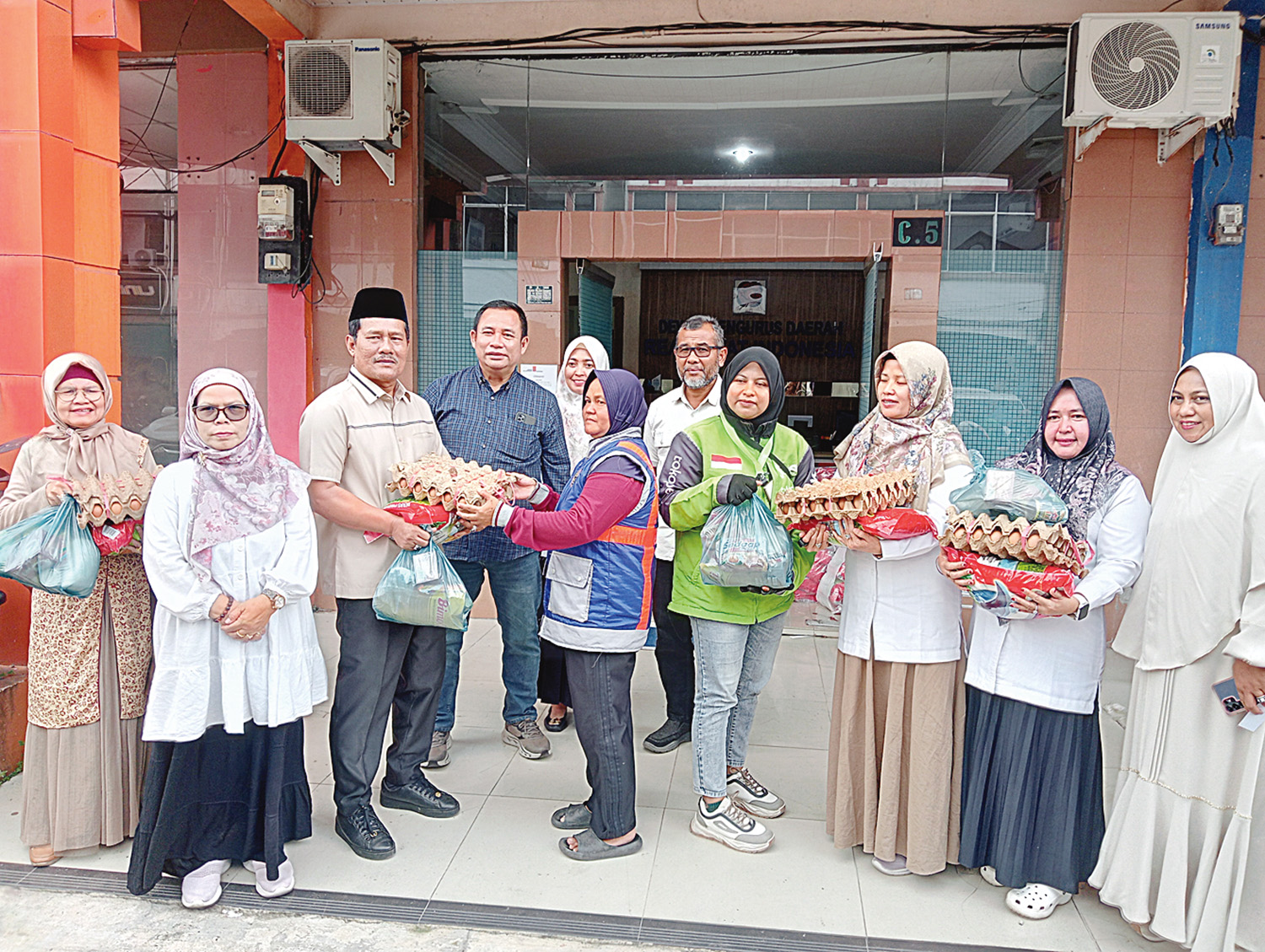 Ketua DPD REI Provinsi Riau Elvi Syofriandi (tiga kiri) bersama jajaran DPD REI Riau menyerahkan bantuan sembako Ramadan kepada driver ojol wanita di Pekanbaru.