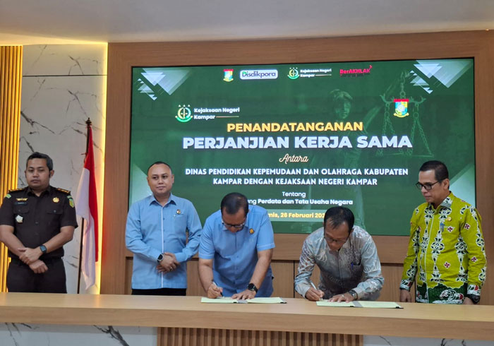 Kajari Kampar Dwianto Prihartono bersama Plt Kadisdikpora Helmi menandatangai kerja sama di Aula Kantor Kejari Kampar, Kamis (26/2/2016).