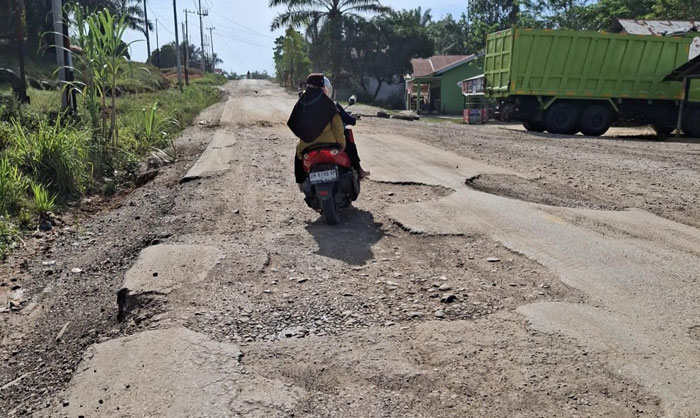 Warga melintas di Jalan Lintas Tengah di Kecamatan Kelayang, Kamis (26/2/2026). Kondisi jalan di daerah itu  rusak.