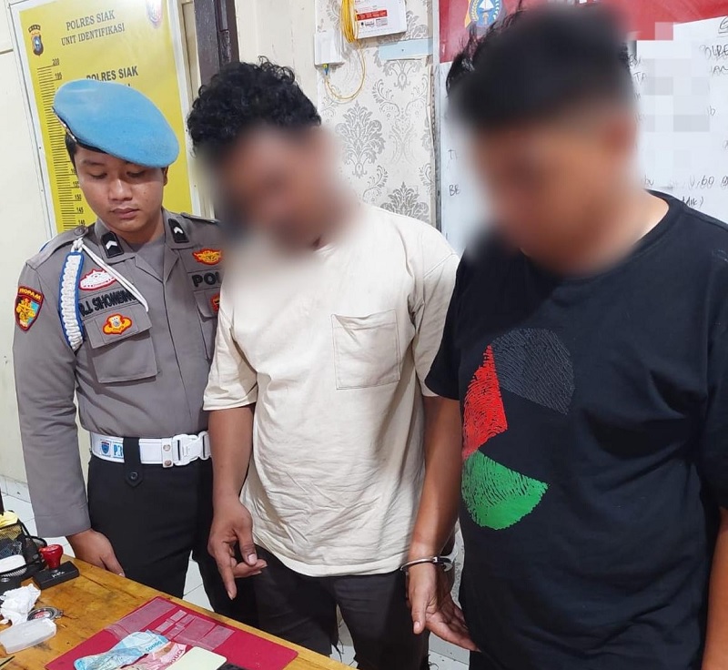 Oknum honorer di Siak, TR (kanan) bersama barang bukti di ruang Satnarkoba Polres Siak, Kamis (26/2/2026).  