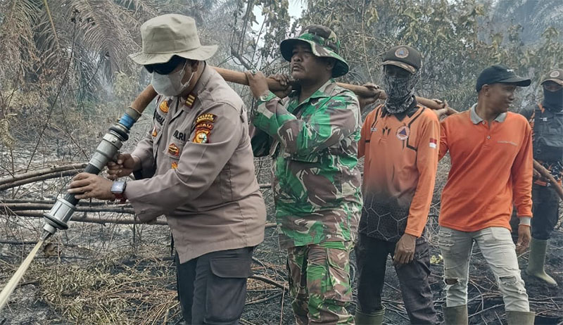 Meski sempat diguyur hujan, namun petugas tetap melakukan pendinginan api Karhutla di Jalan Parit Jawa RT 004/RW 002 Dusun Sungai Mesim 2 Desa Sukarjo Mesim, Kecamatan Rupat, Jumat (27/2/2026). 