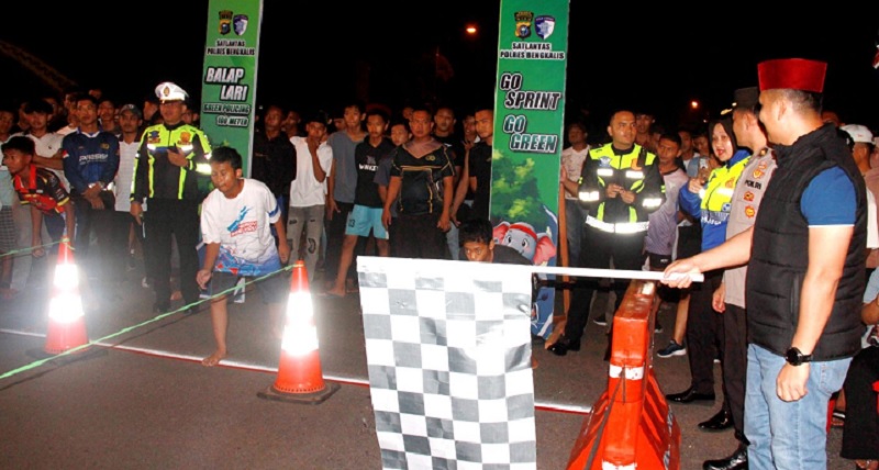 Kapolres Bengkalis AKBP Fahrian Saleh Siregar melambaikan bendera start  balap lari Ramadan di Jalan Pertanian Bengkalis, Sabtu (28/2/2026) malam.