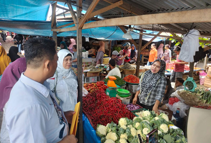 Pejabat fungsional Pengawas Perdagangan Dinas Kopdagrin Kuansing, Herlinawati meninjau pasar modern tradisional Teluk Kuantan, Ahad (1/3/2026).