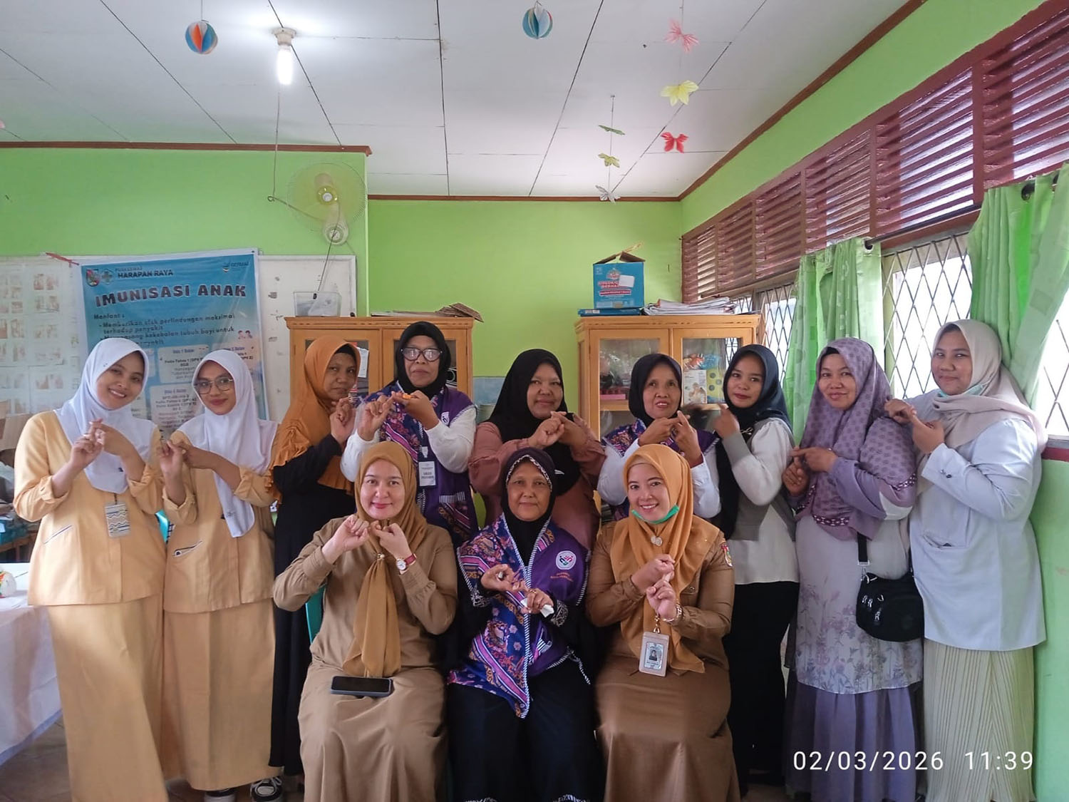 Para kader Posyandu Kuntum Sekaki Hiasan Penuh RW 01 Kelurahan Simpang Tiga, Kecamatan Bukitraya foto bersama bidan, dengan salam 6 SPM, Senin (2/3/2026).