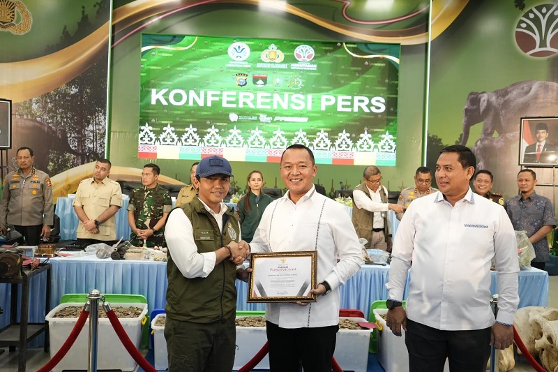 Dirkrimsus Polda Riau Kombes Pol Ade Kuncoro menerima penghargaan dari Menteri Kehutanan Raja Juli Antoni atas pengungkapan kasus perburuan gajah usai ekspos di Mapolda Riau, Selasa (3/3/2026).