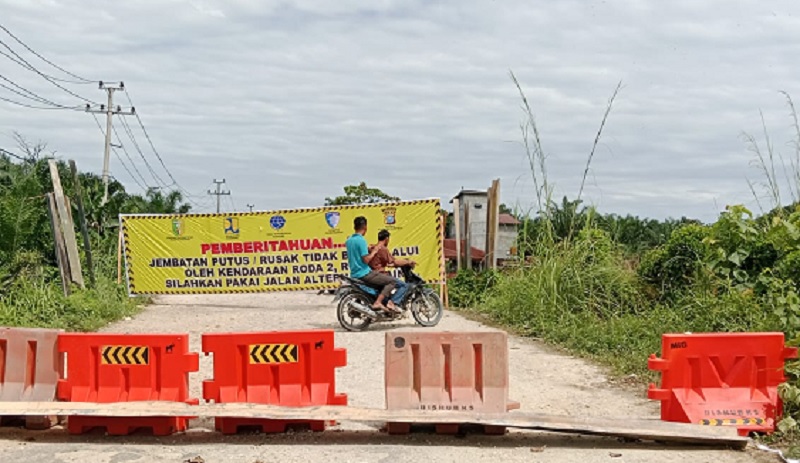 Sudah ditutup, tetapi pengendara roda dua masih tetap melalui Jembatan Sungai Sinambek Kecamatan Sentajo Raya. 