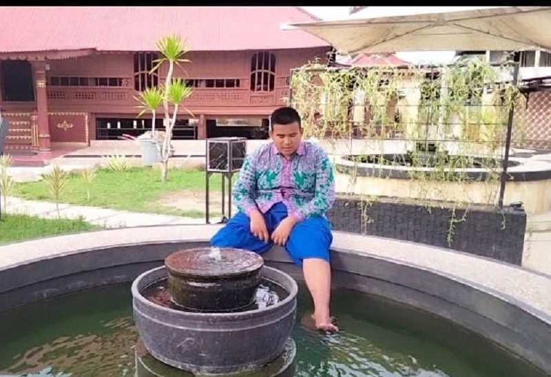 Salah seorang pelajar melakukan terapi ikan di Masjid Jami Air Tiris.