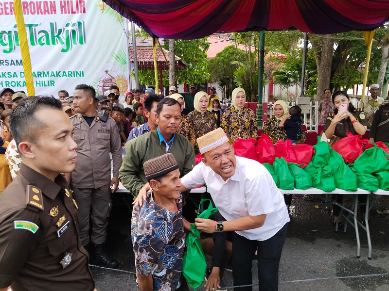 Kajari Rohil Firdaus didampingi Kasi Intelijen Alfriwan Putra saat menyerahkan takjil bagi kepada salah seorang warga Bagansiapiapi.   