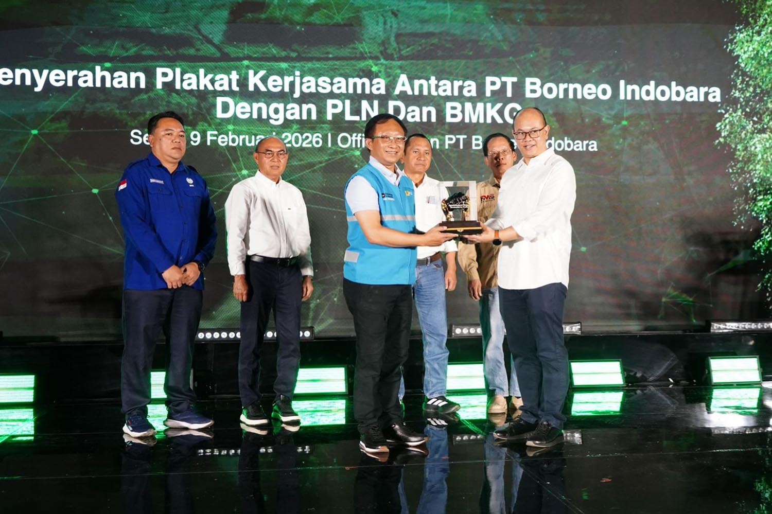 Direktur Retail dan Niaga PLN Adi Priyanto (depan kiri) menyerahkan plakat kepada Direktur Keuangan, Human Capital, dan Manajemen Risiko Energy Management Indonesia. 
