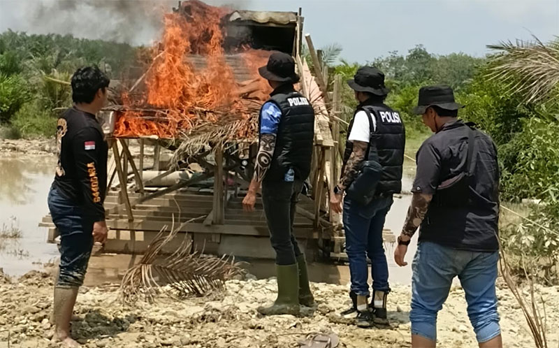 Personel Polsek Benai membakar dua rakit PETI di Desa Gunung Kesiangan yang ditinggakan pemilik dan pekerjanya, Sabtu (7/3/2026).