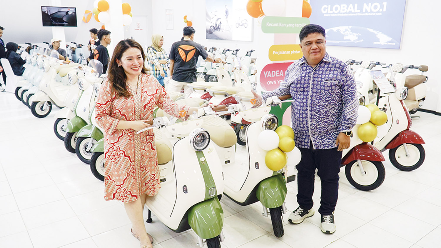 Area Sales Manager Yadea Indonesia Jansinar Purba (Kanan) bersama Retail Manager Yadea Indonesia Angeline Gunawan (Kiri) berfoto di depan Sepeda Listrik Yadea Ova saat launcing Showroom Yadea di berlokasi di Jalan HR Soebrantas No 07-08 Blok C, Simpang De