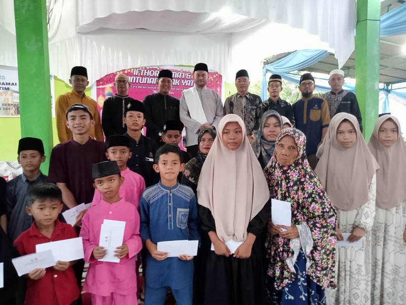 Dari belakang, Ketua RW 001 Edi Yiluza Syuyono (kiri), Ketua RT O15 Fajar (3 kiri) Ustaz Muhammad Amal Fathullah (4 kiri) Kepala Dusun III Junaidi (4 kanan)foto bersama anak yatim, Ahad (8/3/2026),