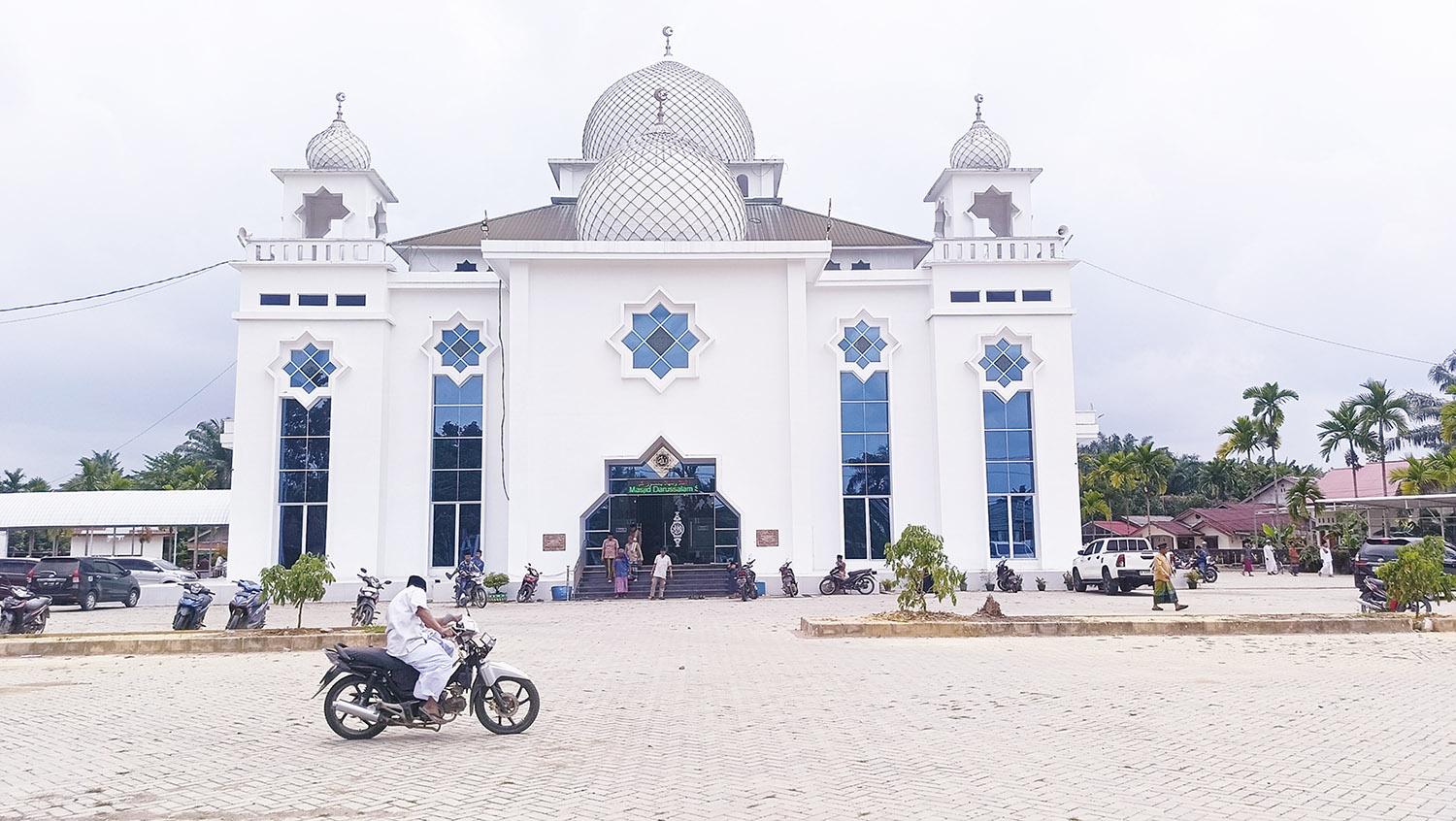 Warga saat melintas di Halaman Masjid Darussalam, Desa Seresam, Kecamatan Seberida, Kabupaten Indragiri Hulu usai melaksanakan salat,  Jumat (6/3/2026).