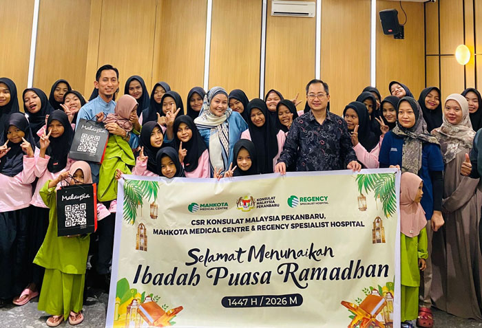 Konsul Malaysia Pekanbaru Muhammed Hosnie Shahiran Bin Ismail (baju biru) dan Neo Peng Soon, Manager Business Development International Marketing MMC (batik) foto bersama anak-anak panti asuhan