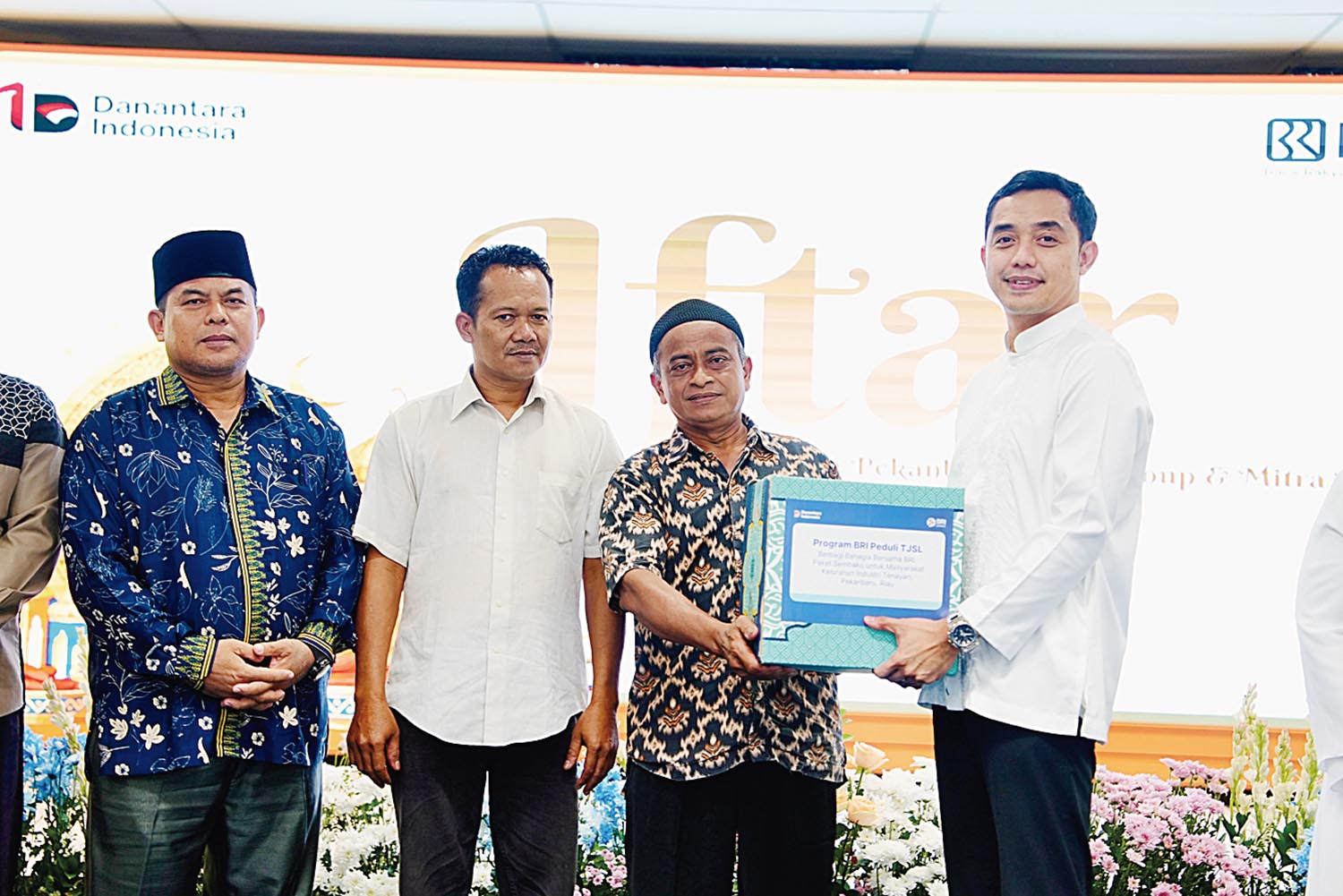 Regional CEO BRI Region 2 Pekanbaru Dian Kesuma Wardhana menyerahkan bantuan saat kegiatan buka puasa bersama serta penyaluran santunan kepada masyarakat.