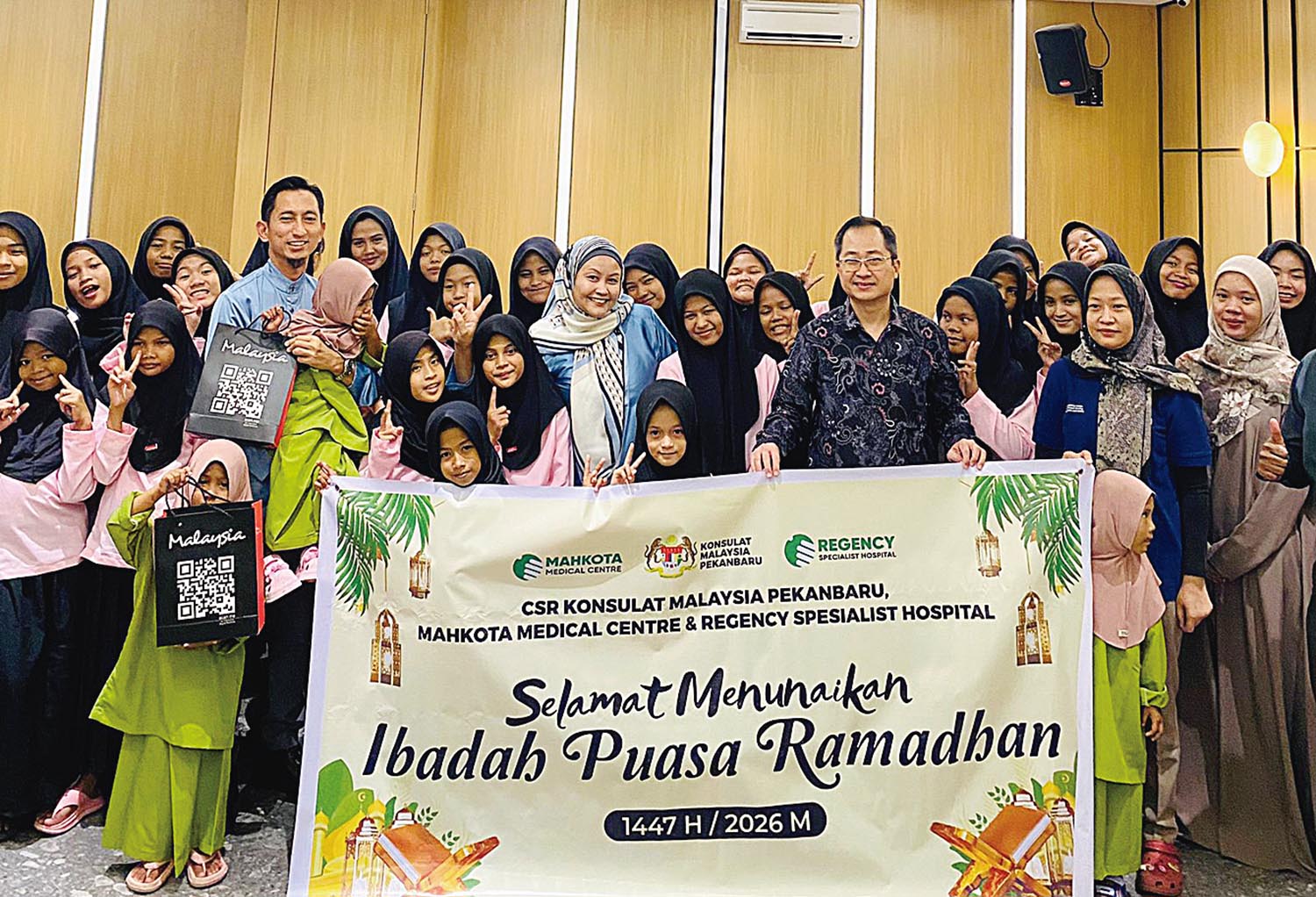 Konsul Malaysia Pekanbaru Muhammed Hosnie Shahiran Bin Ismail (baju biru) bersama Manager Business Development International Marketing MMC Neo Peng Soon (batik dongker) foto bersama anak-anak panti.