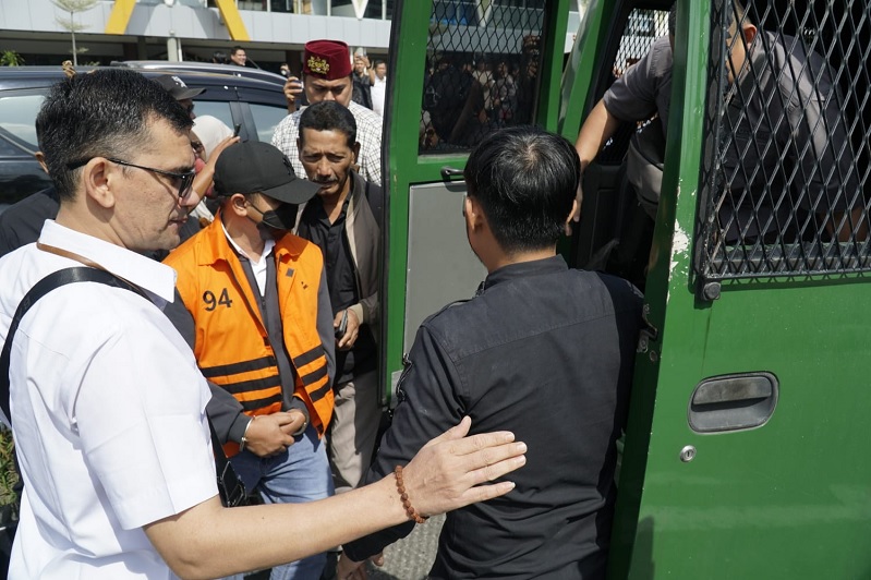 Gubernur Riau Nonaktif Abdul Wahid dengan menggunakan rompi oranye tahanan KPK masuk ke dalam mobil tahnaan di Bandara Sultan Syarif Kasim Pekanbaru,Rabu (11/3/2026). 