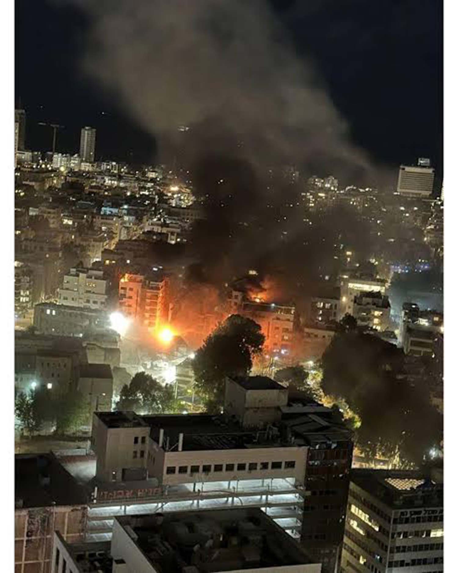 Asap hitam membubung di atas gedung yang terbakar akibat serangan rudal Iran di Tel Aviv, Israel, Rabu (11/3/2026).
