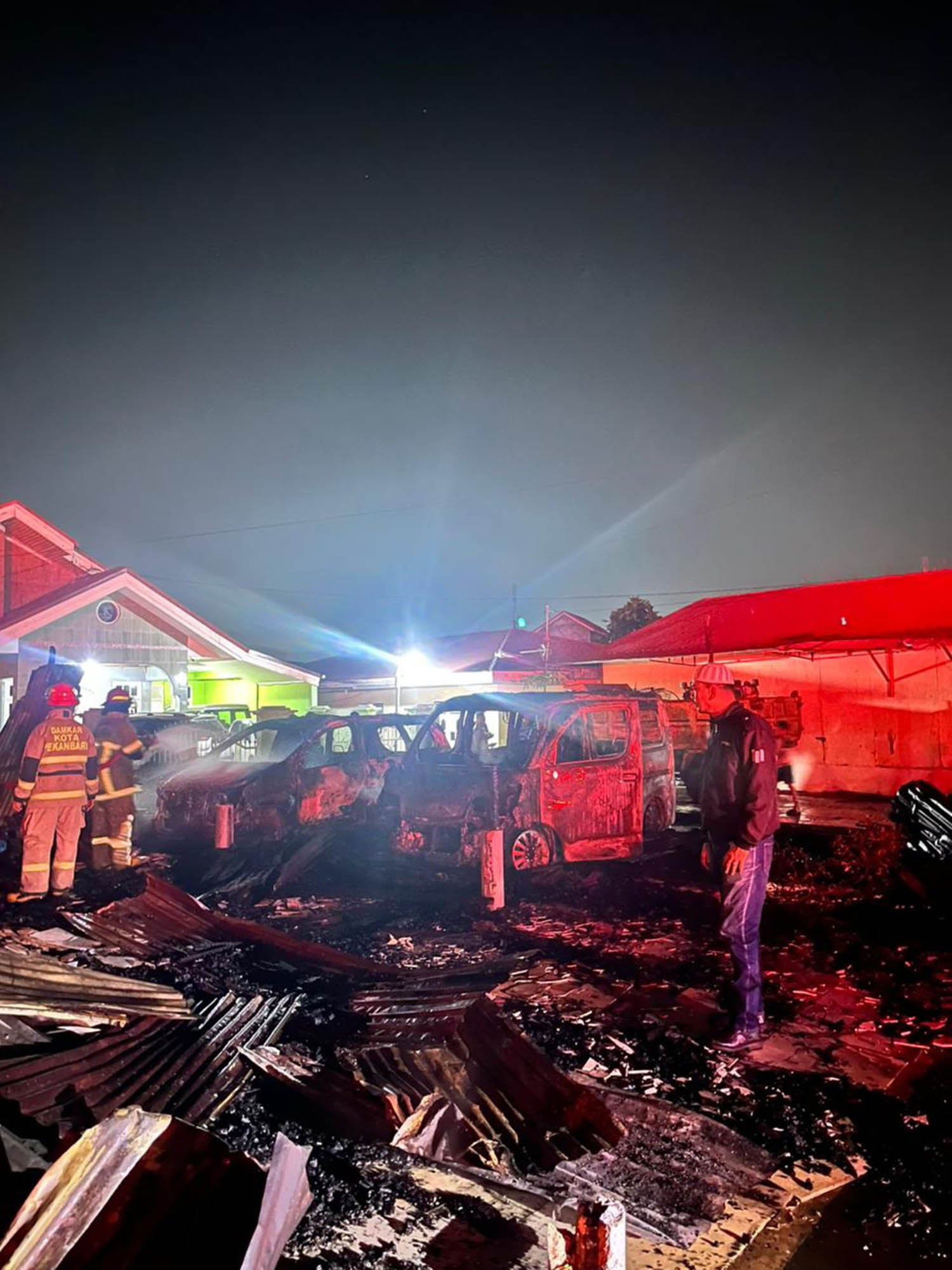 Kondisi bangunan kios semipermanen dan dua mobil yang terbakar menyisakan puing-puing di Jalan Merak, Kecamatan Marpoyan Damai, Rabu (11/3/2026) dinihari.