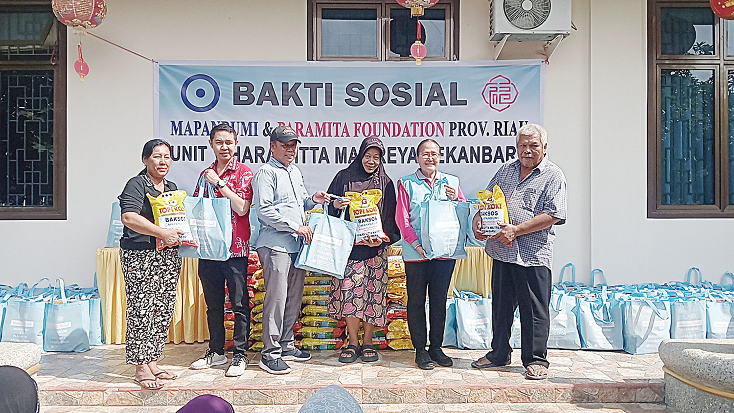 Pimpinan Vihara Citta Maitreya Rosa Ria (dua kanan) didampingi Wakil Bendahara PSMTI Riau Andry (dua kiri) secara simbolis menyerahkan paket Hari Raya Idulfitri.