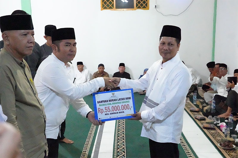Wabup H Muklisin menyerahkan bantuan rumah layak huni pada Plt Camat Sentajo Raya Wandi Gunawan saat safari Ramadan Pemkab di Desa Geringging Baru Kecamatan Sentajo Raya. 