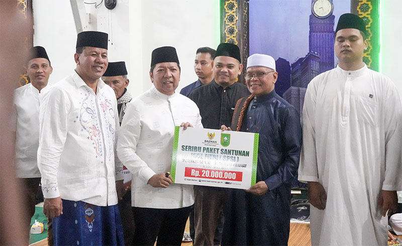 Asisten I Setdaprov Riau, H Zulkifli Syukur didampingi Bupati Kuansing H Suhardiman Amby menyerahkan bantuan seribu paket santunan Pemprov-Baznas di Masjid Agung Ar Raudha Kuansing, Kamis (12/3/2026) 
