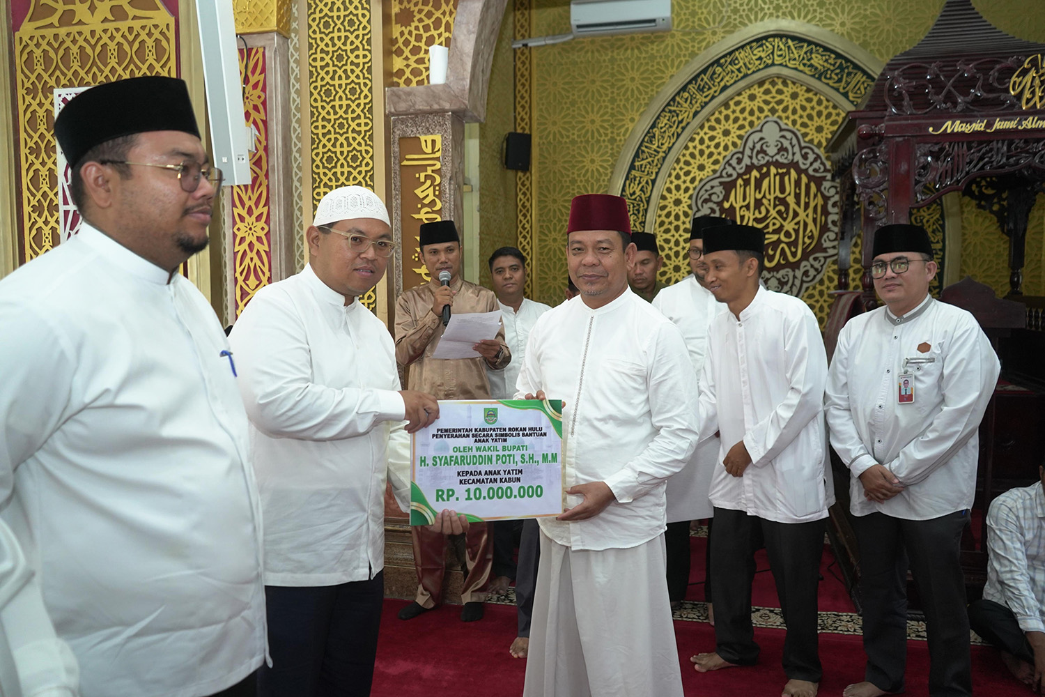  Wabup Rohul H Syafaruddin Poti menyerahkan santunan anak yatim kepada perwakilan Camat Kabun Anang Perdhana Putra dalam acara kunjungan Safari Ramadan Pemkab Rohul di Masjid Al Mu&rsquo;awwanah.