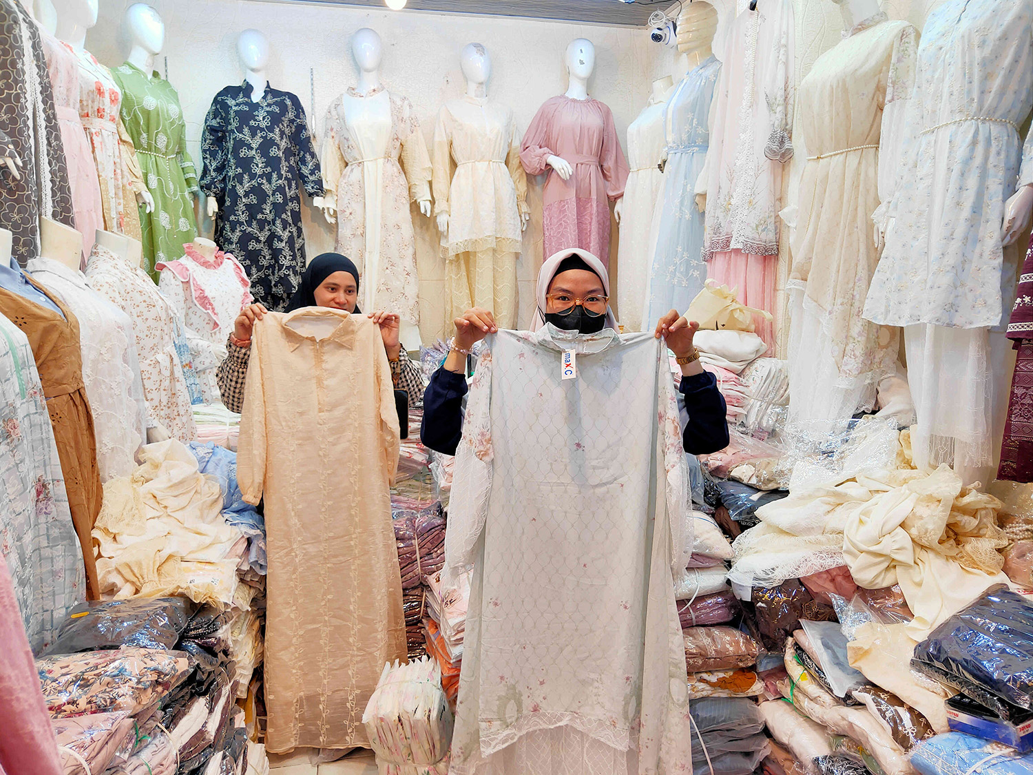Pedagang baju di lantai dasar Sukaramai Trade Center Pekanbaru memperlihatkan contoh model gamis bini sah (kiri) dan gamis bini orang (kanan) yang jadi tren fesyen Idulfitri tahun ini.