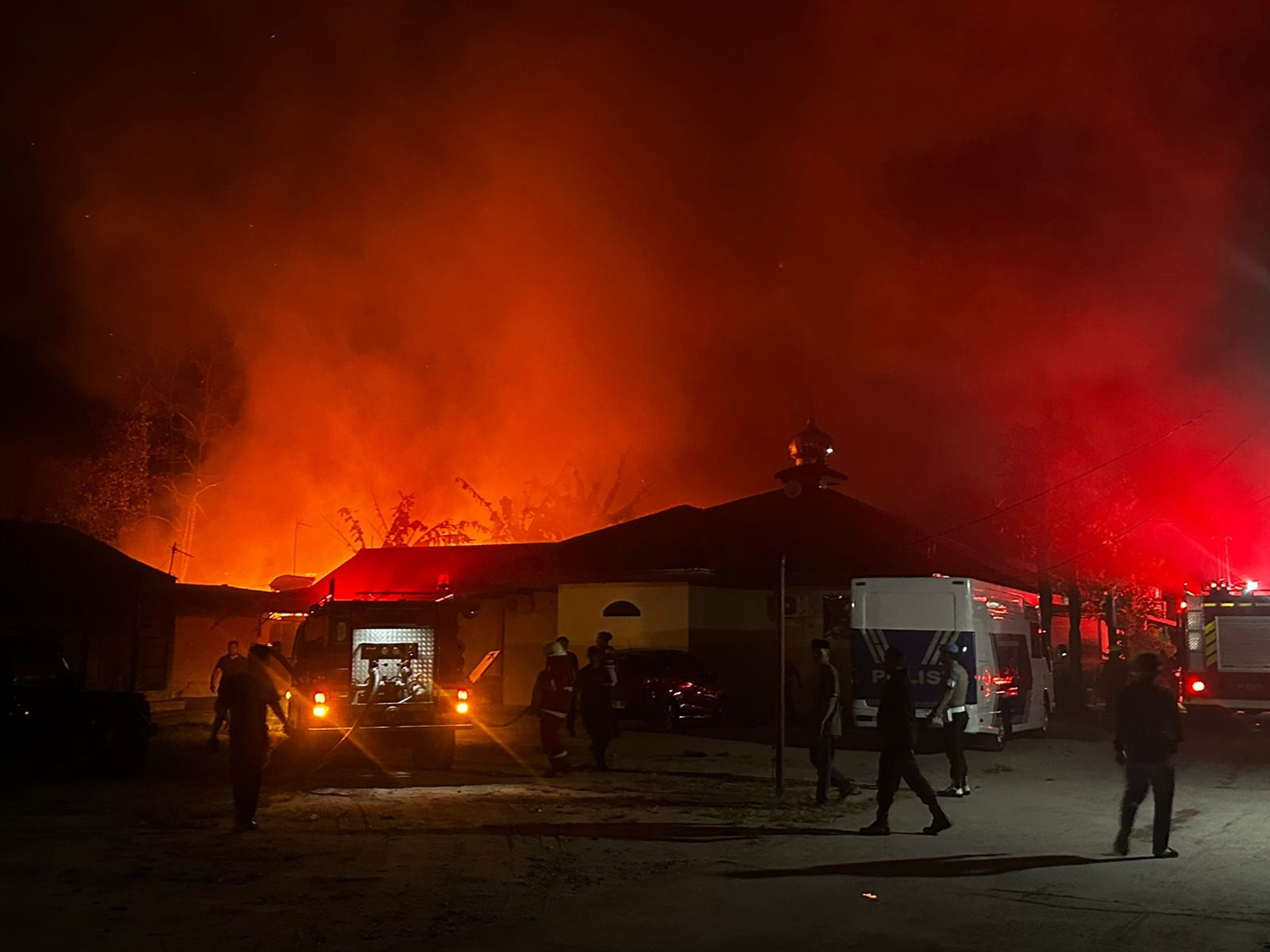 Petugas damkar dan kepolisian melakukan pemadaman api yang membakar rumah Asrama Polisi, Jalan Sisingamangaraja, Kamis (12/3/2026) malam.