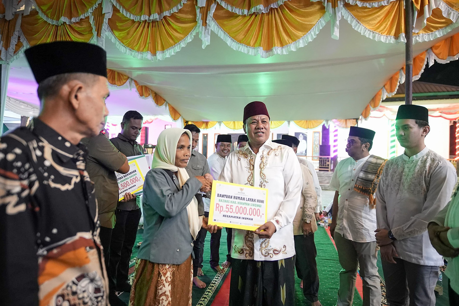 Bupati Kuansing Dr H Suhardiman Amby MM menyerahkan bantuan rumah layak huni dari Baznas Kuansing saat Safari Ramadan di Pondok Pesantren Imam Saleh, Kecamatan Inuman, Senin (9/3/2026).